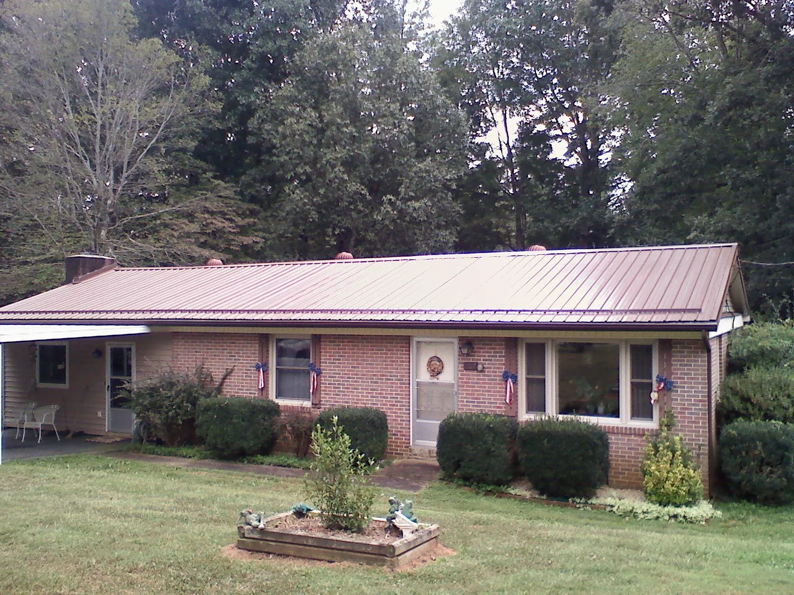 Bronze metal roof on a brick ranch home with a carport in Danville